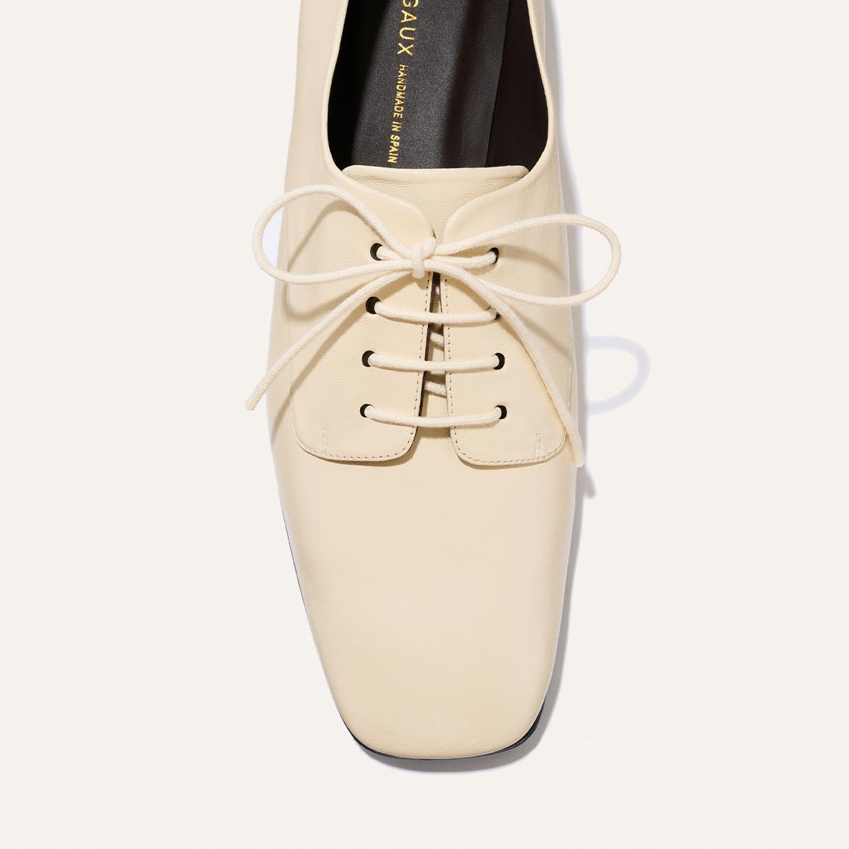 The Billie Derby - Vanilla Nappa by Margaux, a cream-colored leather lace-up oxford featuring four eyelets on each side and a neatly tied bow, is photographed from above against a white background.
