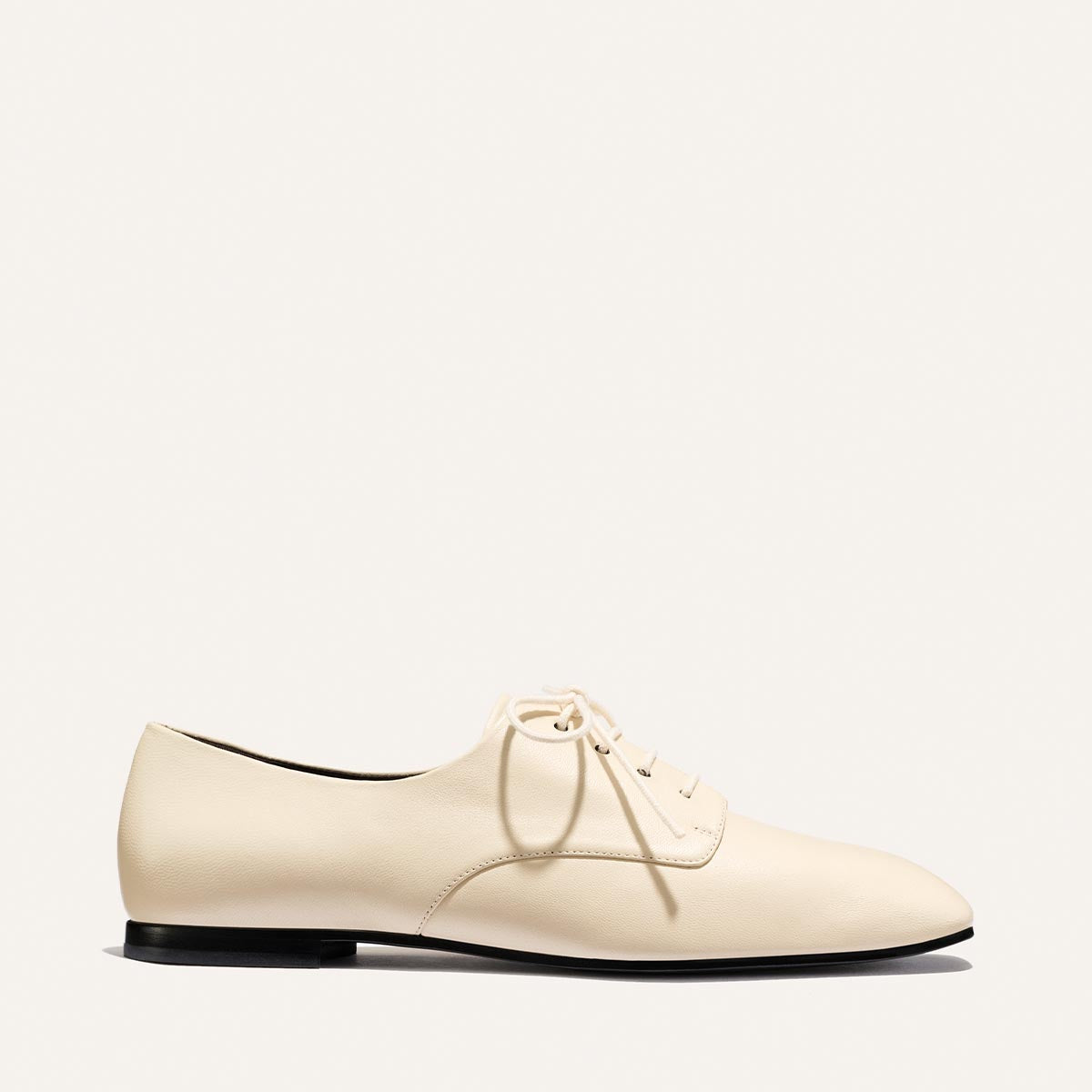 A single Margaux Billie Derby shoe in Vanilla Nappa leather, featuring cream-colored laces and seen from the side, displayed on a plain light background.