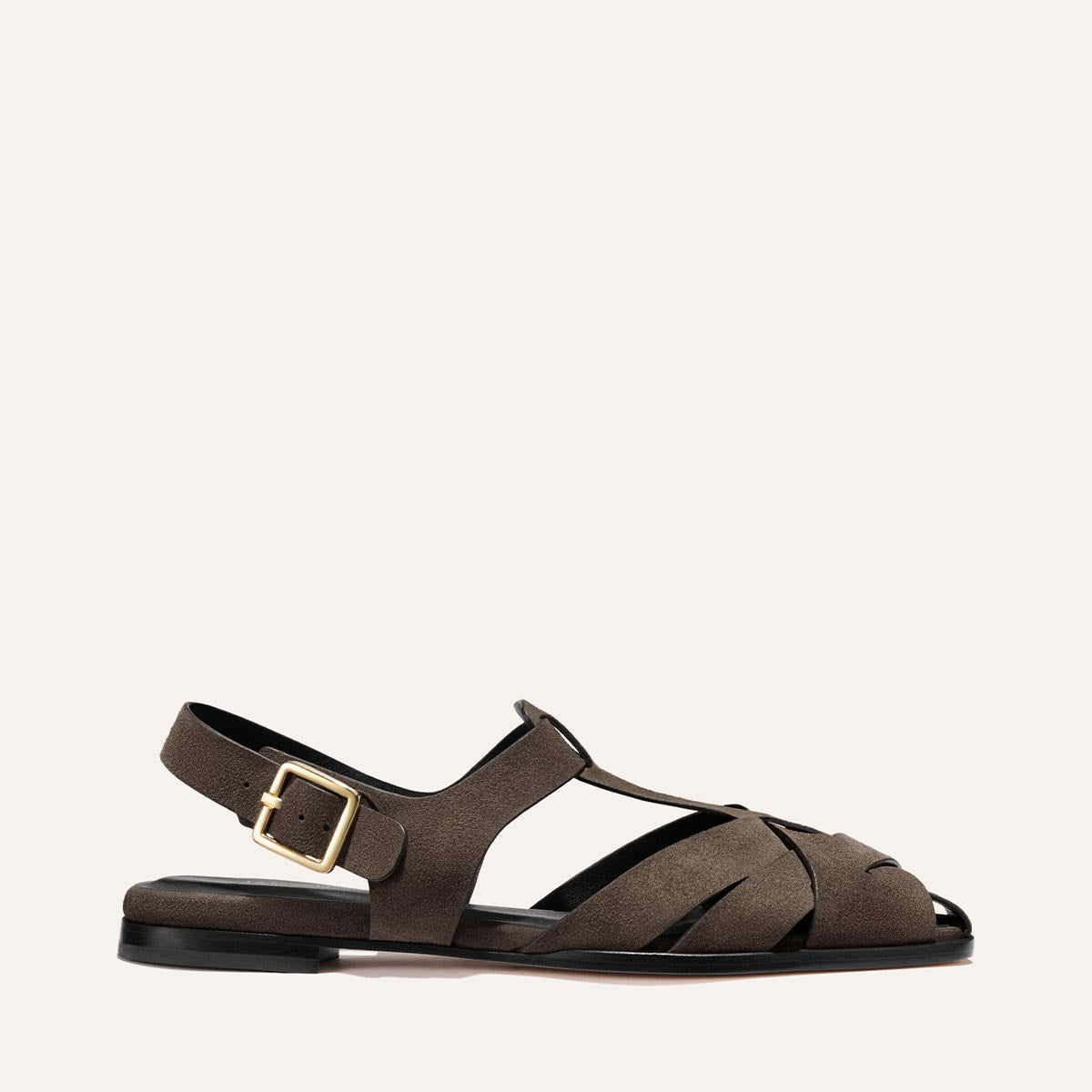 The Calypso Fisherman by Margaux in English Brown Suede is a flat sandal with closed toe, interwoven design, cutouts, ankle strap, and gold buckle for secure fit. Shown against a plain light background.