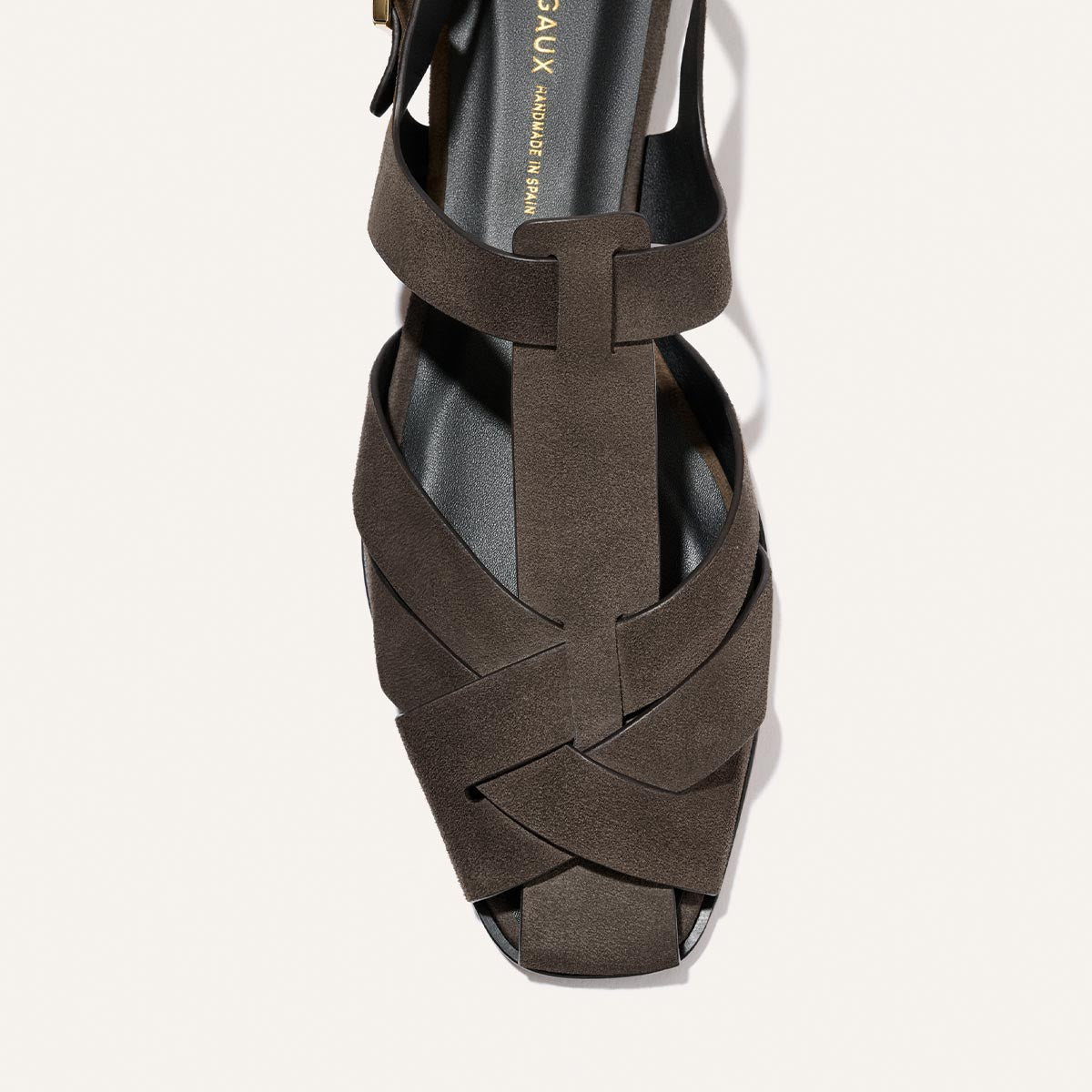 A top view of Margaux’s The Calypso Fisherman in English Brown Suede, showcasing modern interwoven crisscross suede straps, an open toe, and a black footbed for a secure fit.