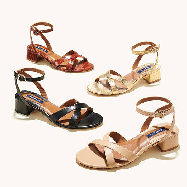Four pairs of women’s open-toe sandals with ankle straps and low block heels in brown, gold, black, and beige, displayed on a light background.