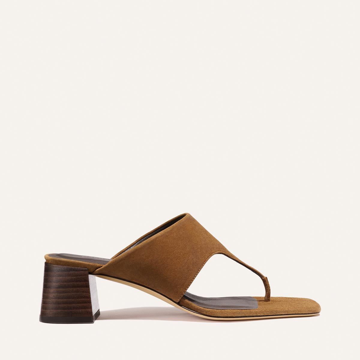 The Deia 50 by Margaux in nutmeg suede features a heeled sandal design with an open toe, thick upper strap, thong-style front, and stacked block heel, shown against a plain white background.
