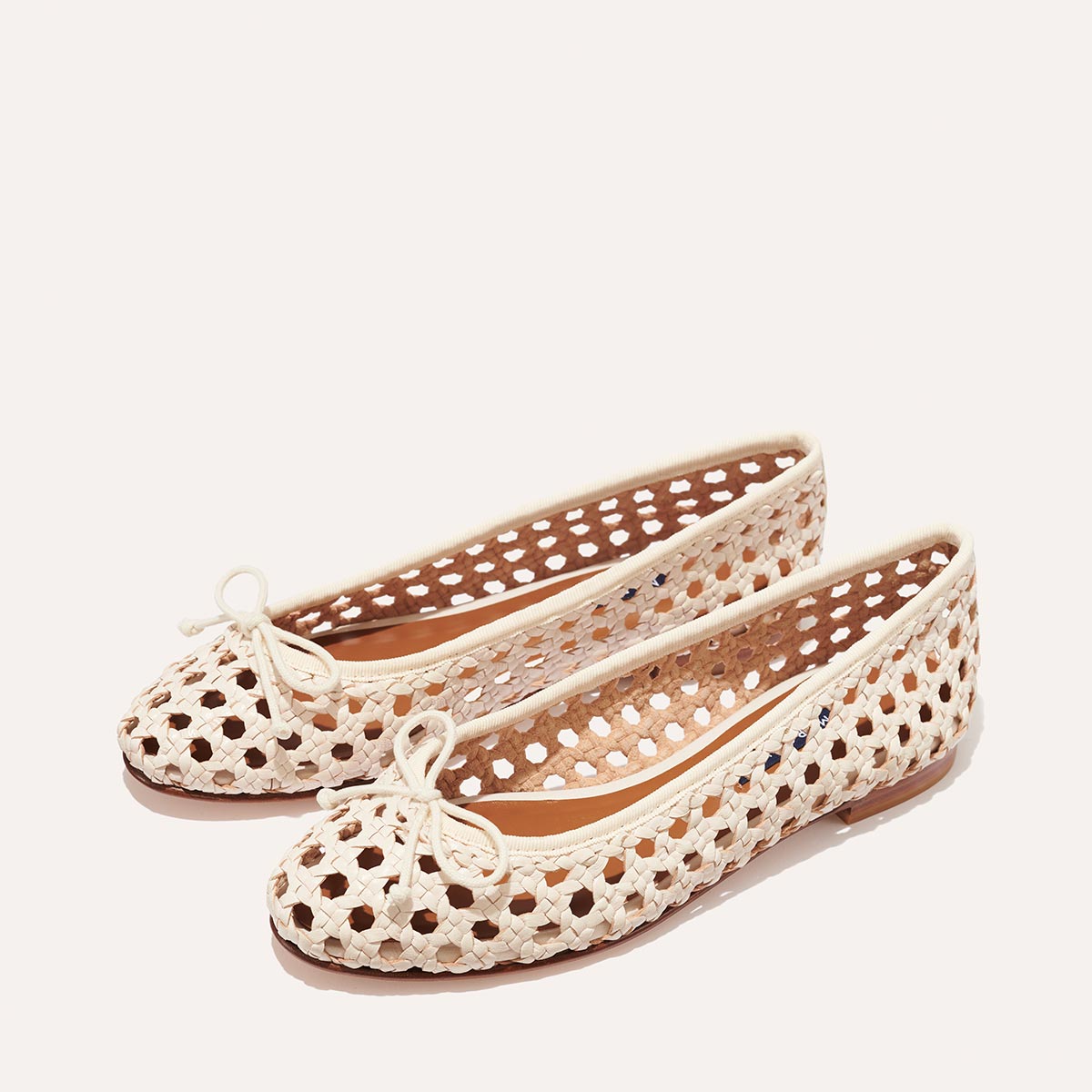 The Demi - Ecru Woven Leather by margaux-development: cream woven leather ballet flats with round toes, bow detail, and open perforated sides, handmade in Spain and shown on a plain white background.