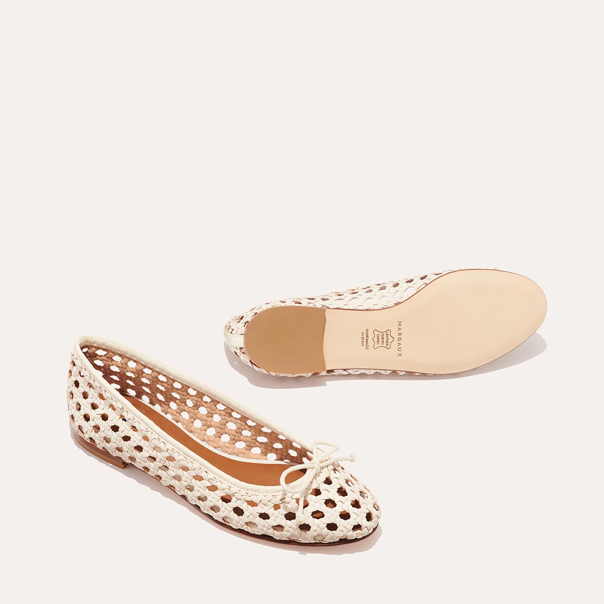 The Demi - Ecru Woven Leather by margaux-development: handmade ballet flats in cream woven leather, featuring a toe bow; one shoe displays the intricate weave, while the other reveals the smooth sole and brand stamp.