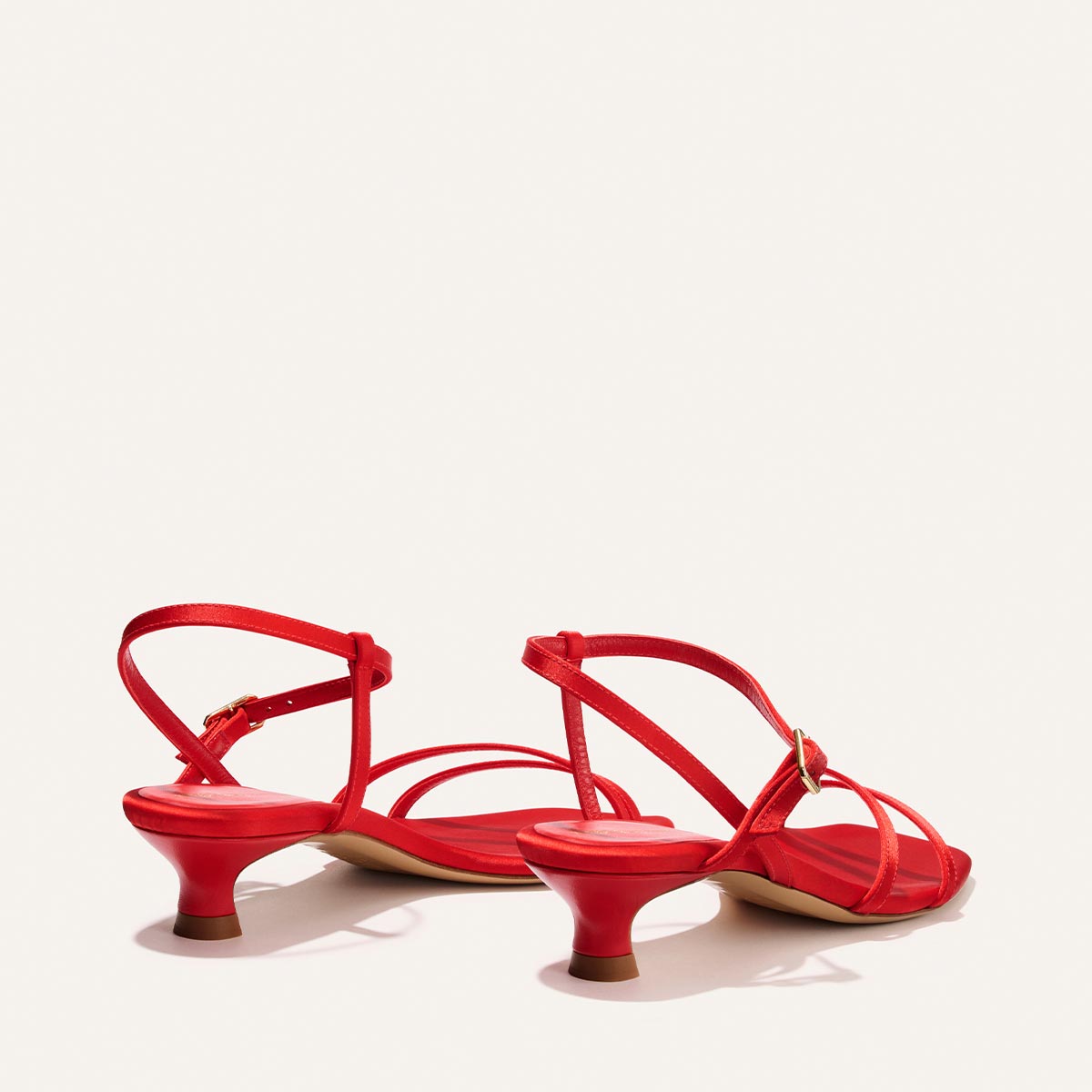 The Dylan Sandal - Poppy Satin by Margaux: red strappy kitten-heeled sandals with ankle straps, shown from the back and side on a plain light background.