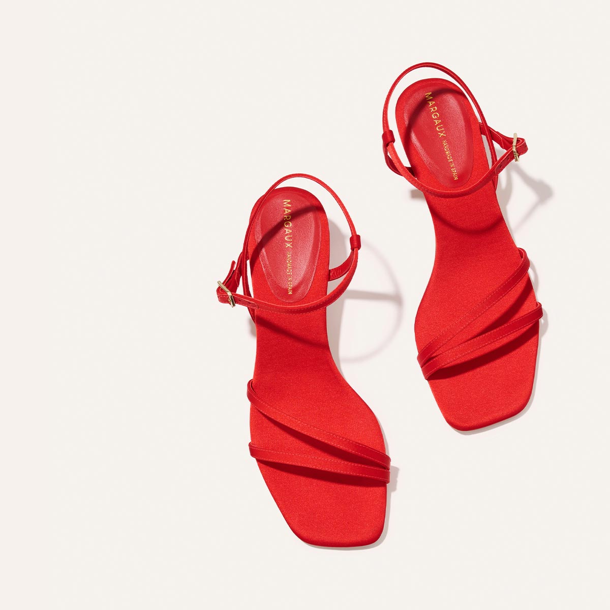 The Dylan Sandal - Poppy Satin by Margaux features bright red satin, open toes, ankle straps, and low block heels, beautifully displayed on a light background.