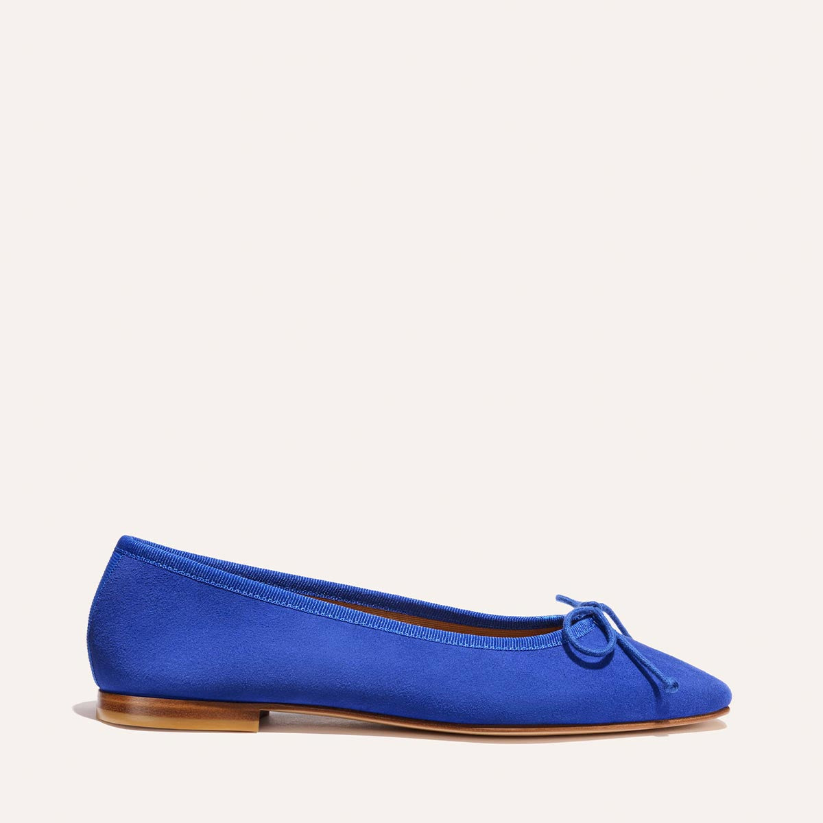 The Fonteyn - Cobalt Suede by Margaux: a handcrafted cobalt blue ballet flat with a comfort-first fit, small toe bow, and thin brown sole. Displayed in profile on a plain light background.