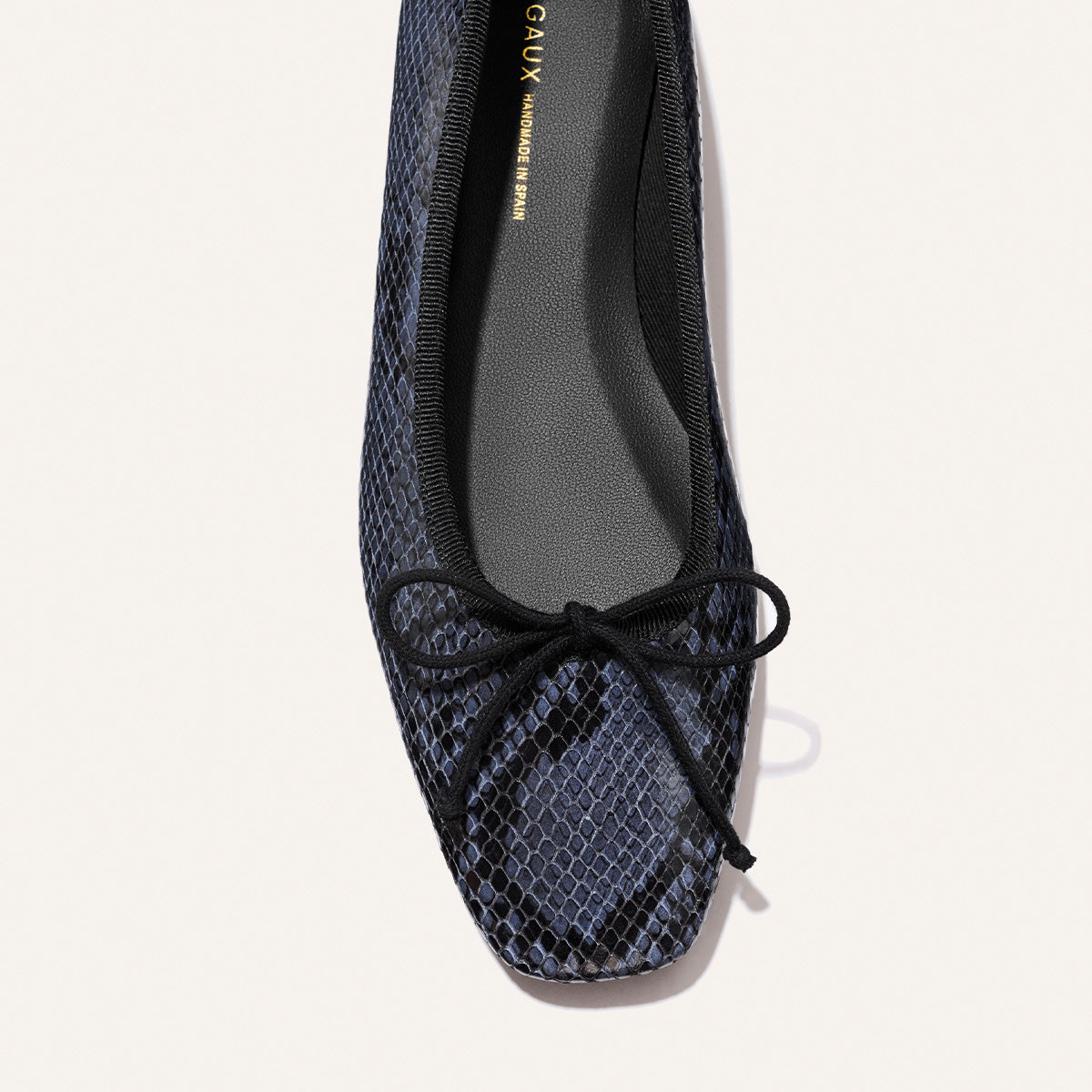 The Fonteyn - Fumo Python Embossed by Margaux: a black ballet flat with a textured snakeskin pattern and bow on the toe, shown from above against a light background.