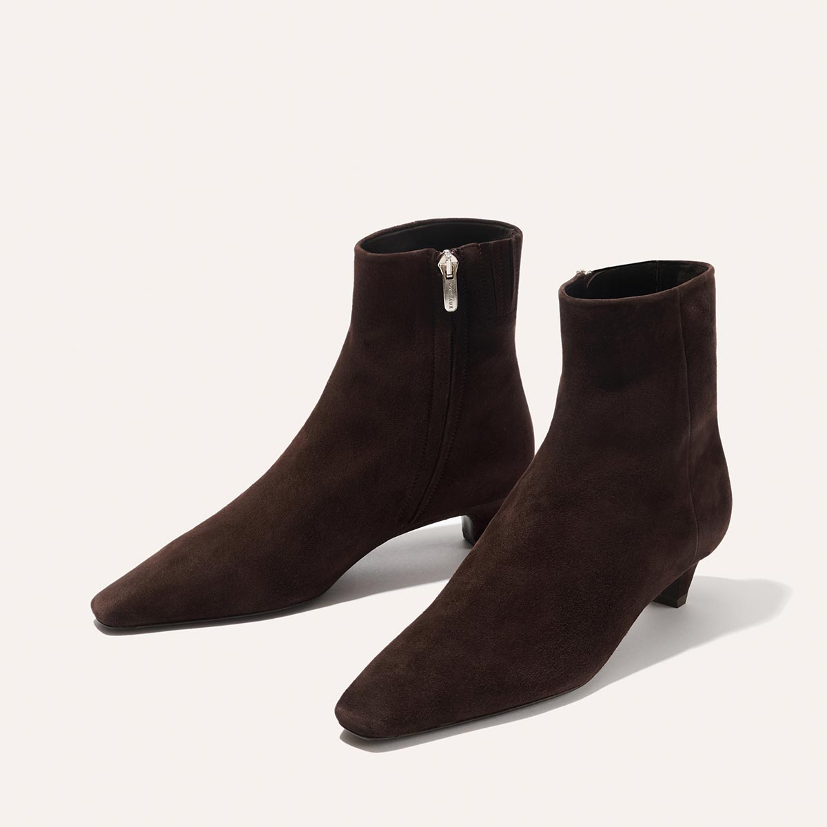 The Inga - Espresso Suede by margaux-development features dark brown suede, pointed toes, low kitten heels, and side zippers—an on-the-go staple for New York City style—displayed against a plain light background.