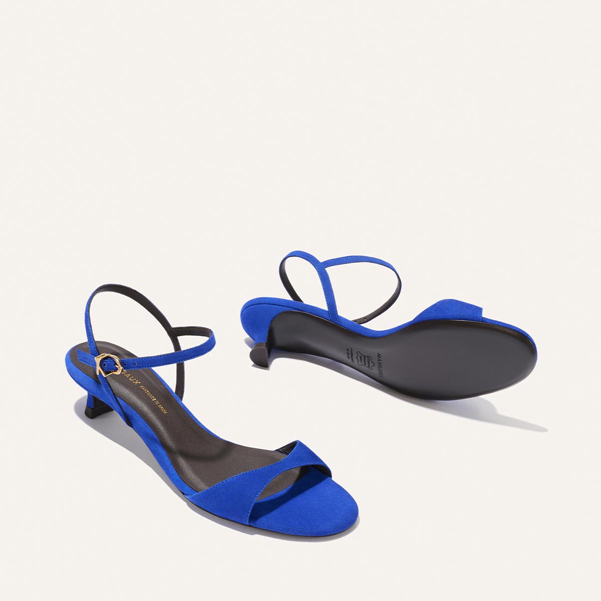 The Margaux Lotto 35 in Cobalt Suede: women's minimal blue sandals with low kitten heels, tapered straps, open toes, and ankle straps with small buckles. Shown on a light background—one upright, one on its side to reveal the sole.