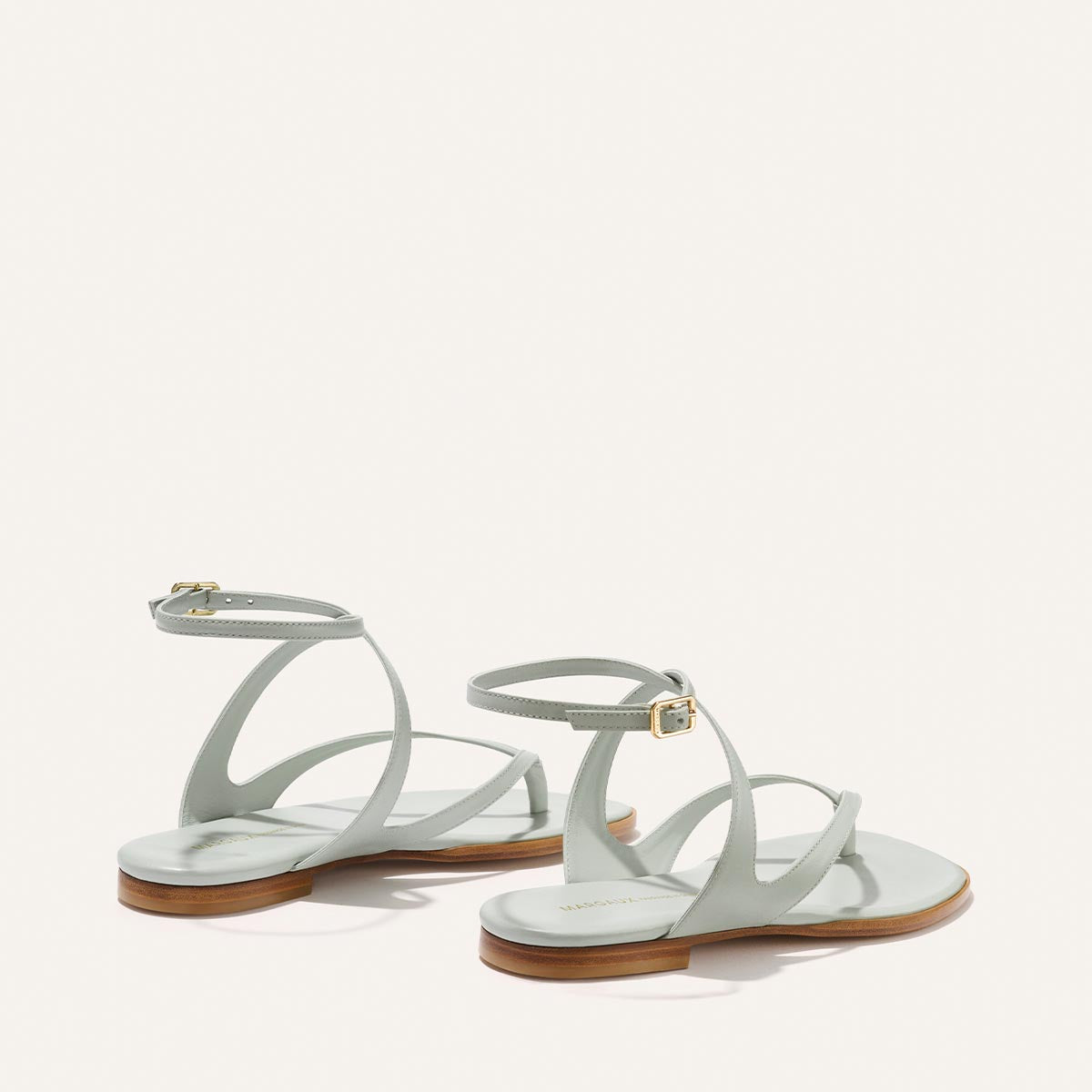 Pair of light blue sandals with wooden soles on a white background