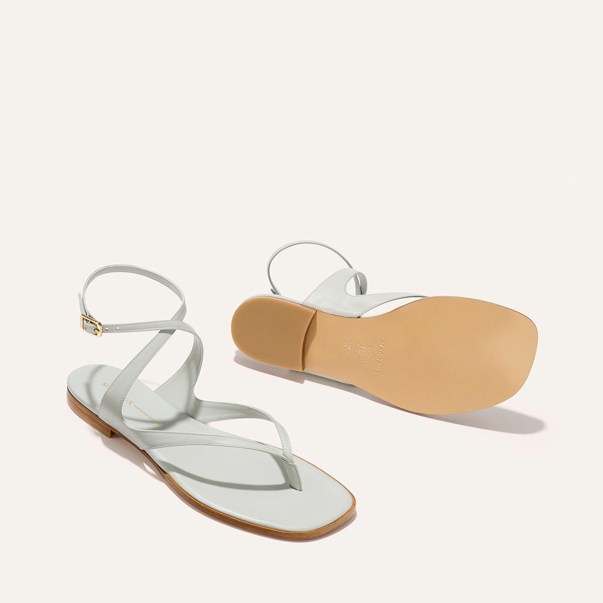 Light blue sandal with a tan insole on a light pink background