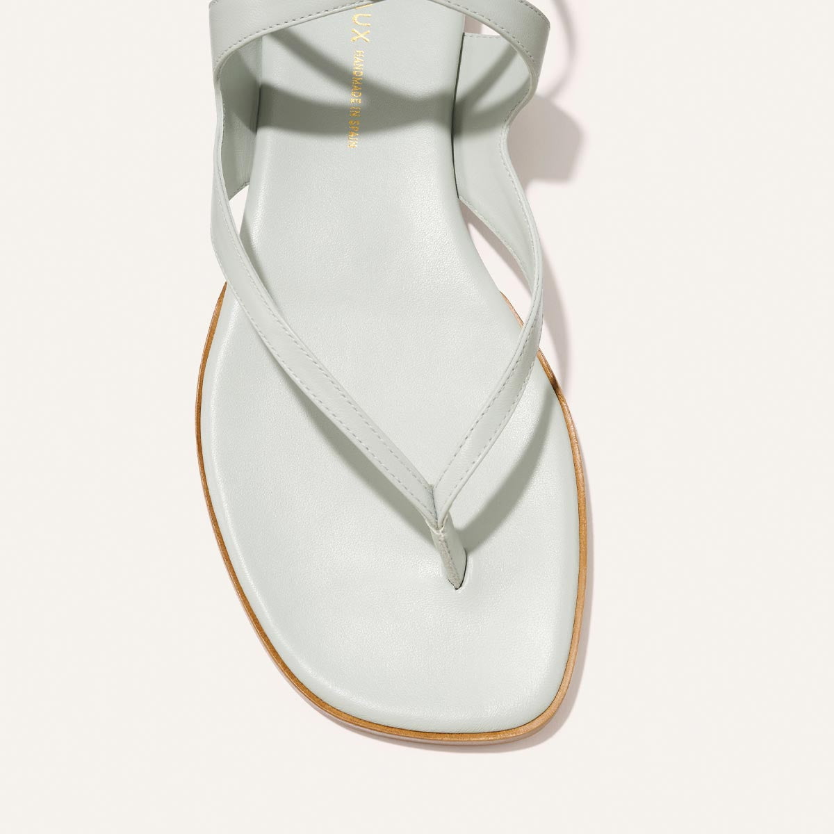 Light blue sandal with a thong design on a white background