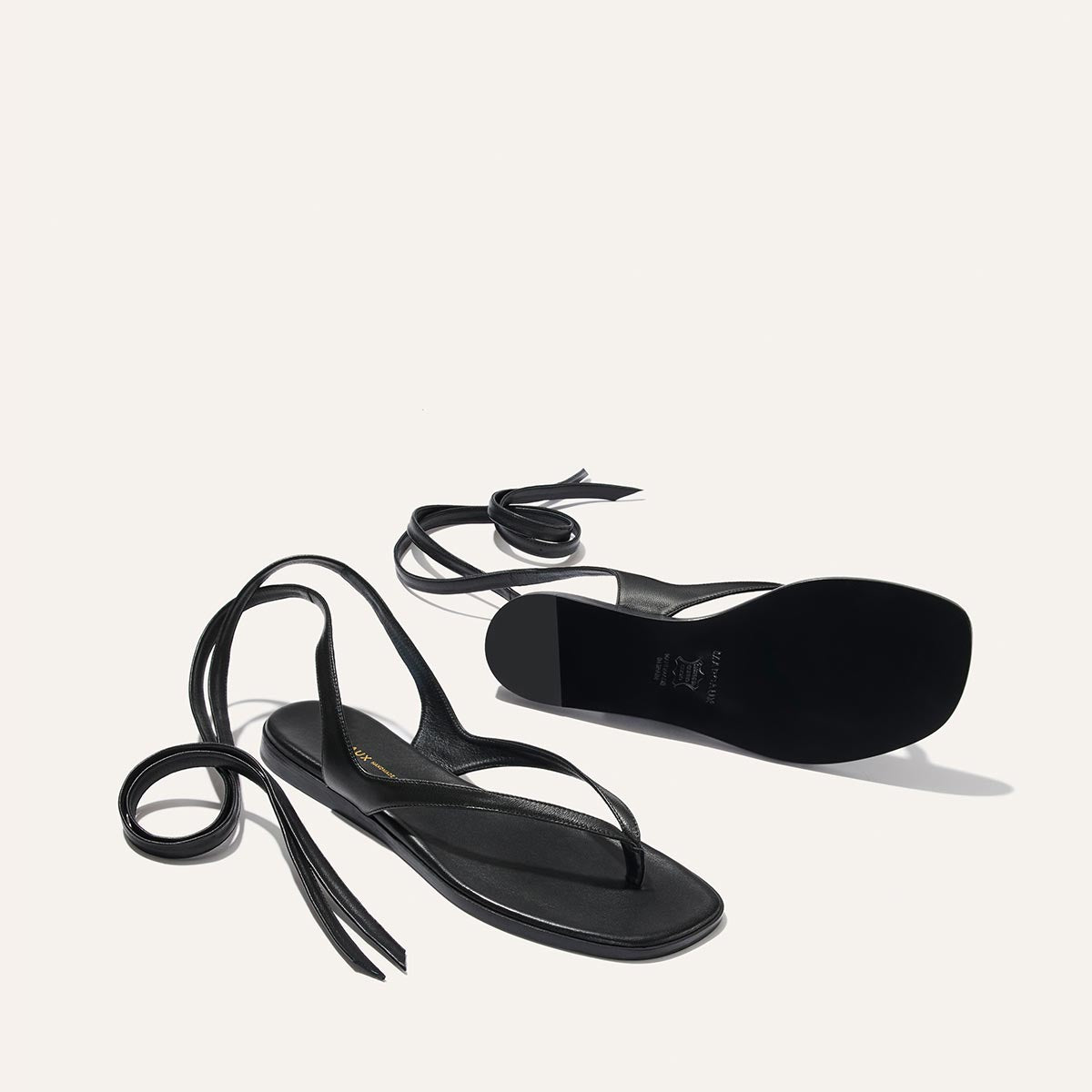 Black sandals with thin straps on a white background