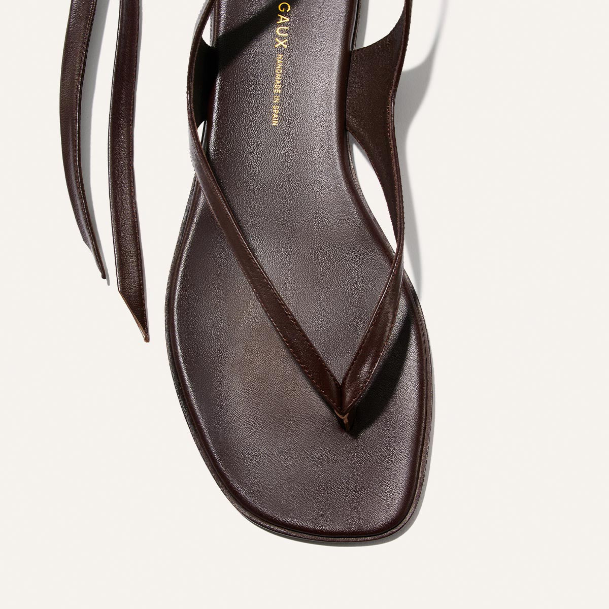 A close-up of Margaux’s Palermo Wrap Sandal in Espresso Nappa, featuring a minimalist square toe, cushioned insole, sleek leather finish, and thin straps—perfect chic sandals for summer getaways.