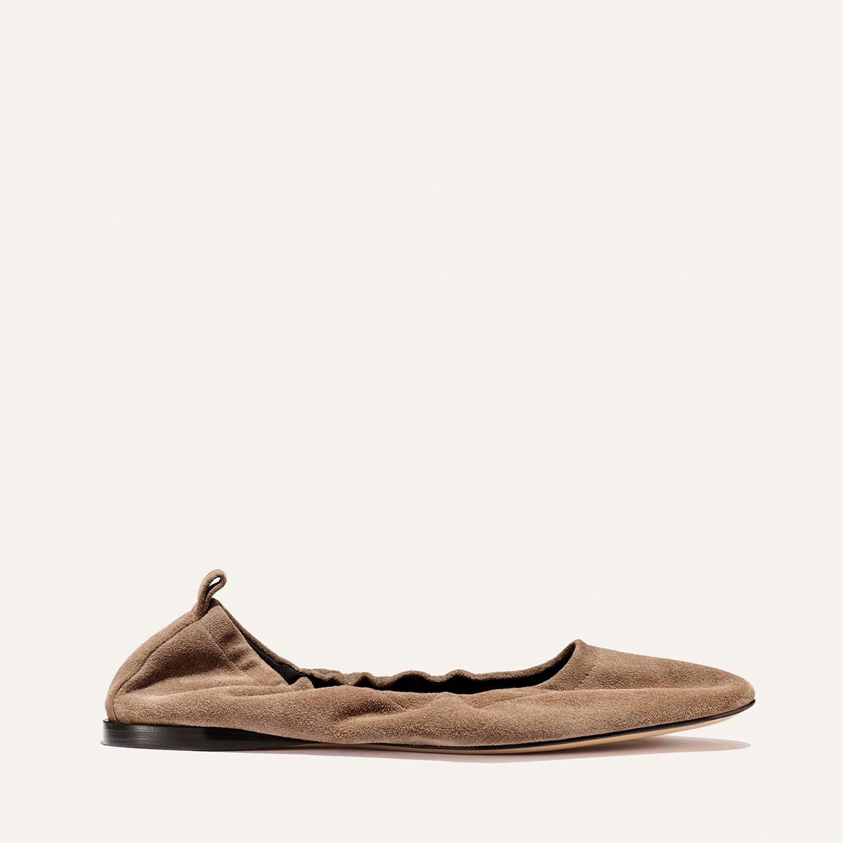 The Pascale - Cappuccino Suede by Margaux: a single brown suede ballet flat with a ruched, elasticated back, low black sole, and small heel pull tab, displayed on a plain white background.