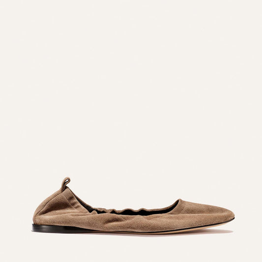 The Pascale - Cappuccino Suede by Margaux: a single brown suede ballet flat with a ruched, elasticated back, low black sole, and small heel pull tab, displayed on a plain white background.