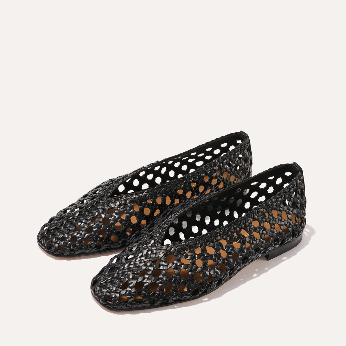 The Woven Paz SS25 - Black Leather flats by Margaux, featuring a handwoven pointed-toe design and airy open structure, are shown against a plain white background.