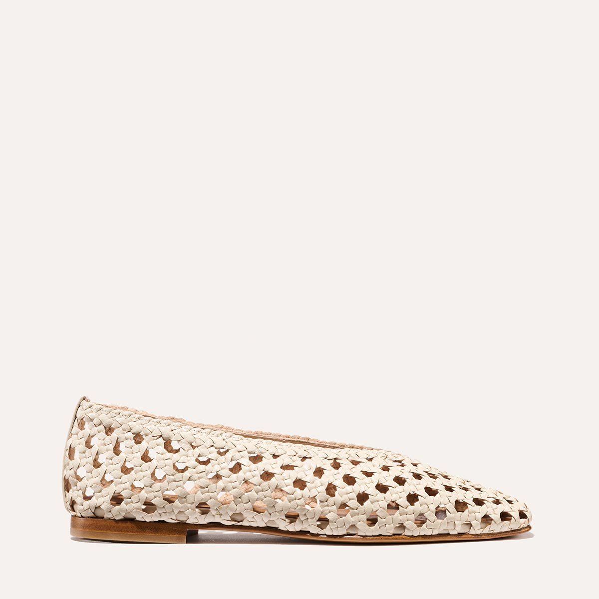 A side view of Margaux's The Woven Paz SS25 in Ecru Leather, featuring a handwoven design, pointed toe, and slim brown sole, set against a plain light background.