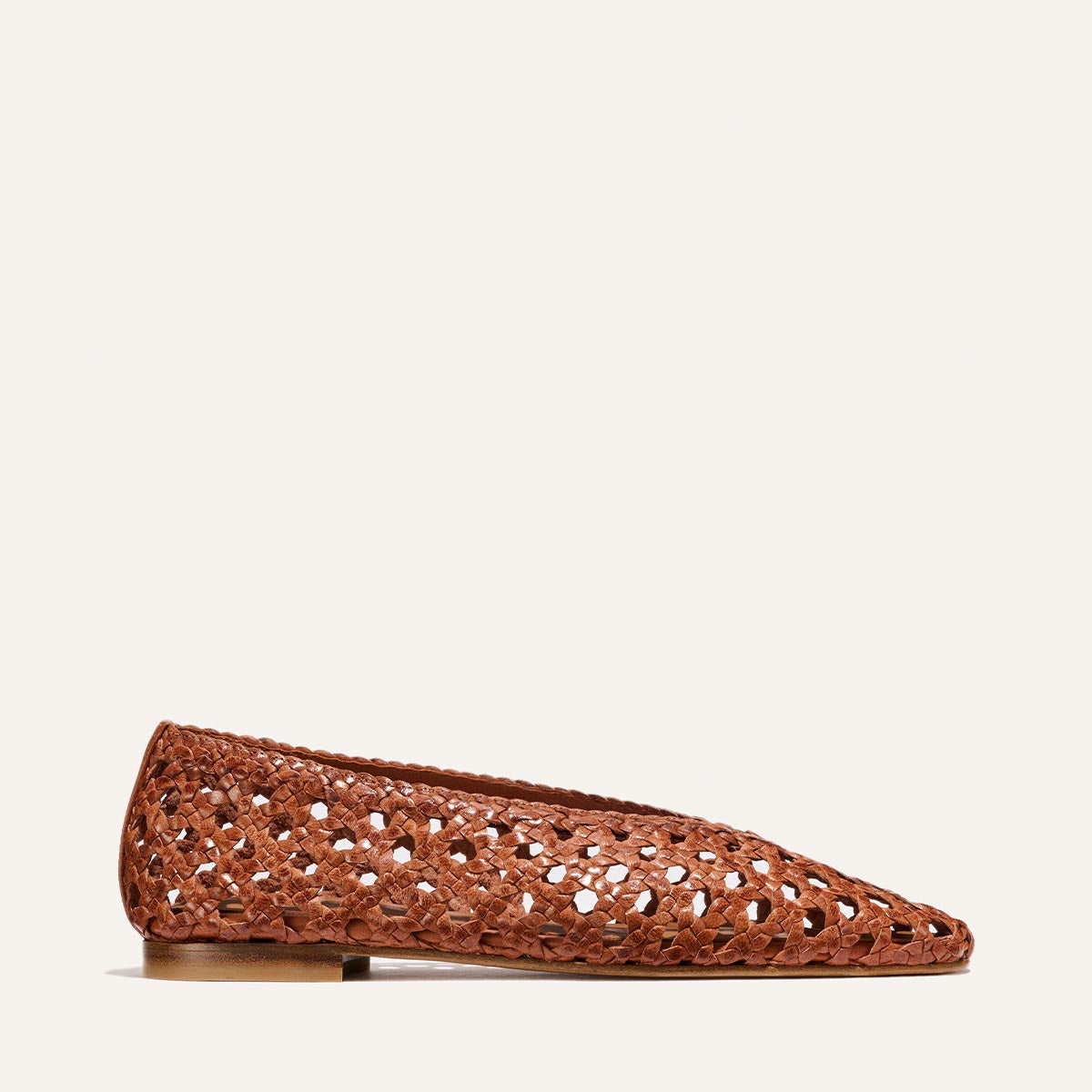 The Woven Paz - Saddle Woven Leather by Margaux is shown in profile against a white background, featuring luxuriously soft handwoven brown leather, a pointed toe, and an elegant cutout pattern throughout.