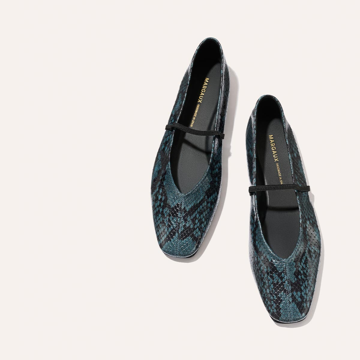 Aqua python-embossed The Phoebe Mary Jane flats by Margaux, featuring black straps, a square toe, and visible Margaux branding on the insole, displayed on a light background.