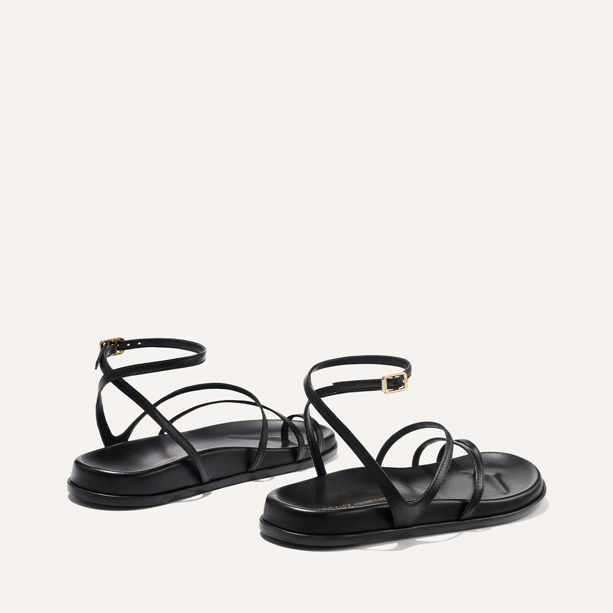 Black strappy sandals on a white background