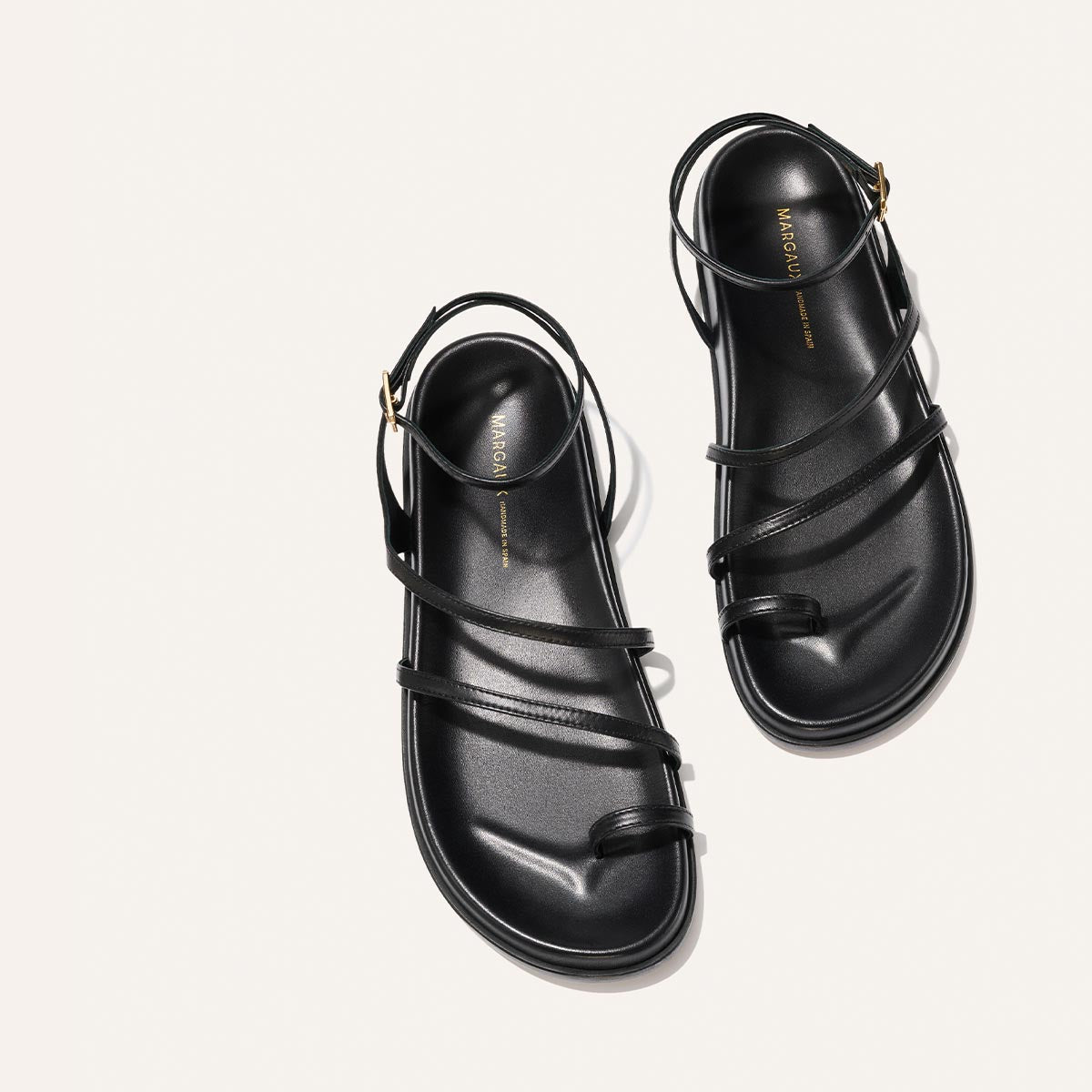 Black strappy sandals on a white background
