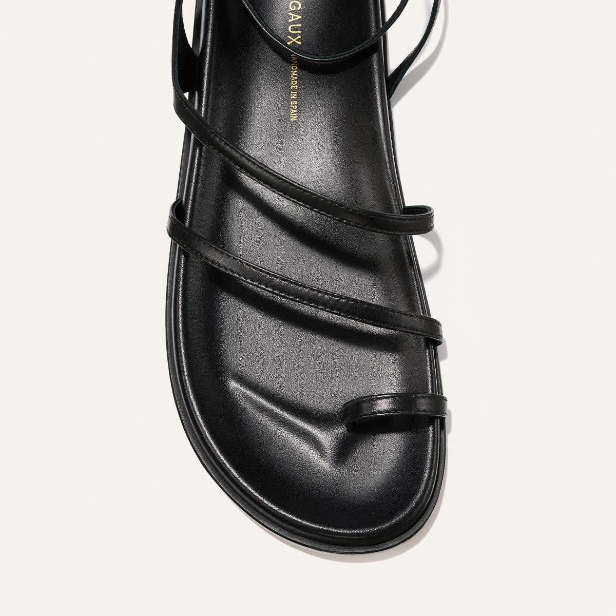 Black sandal with multiple straps on a white background