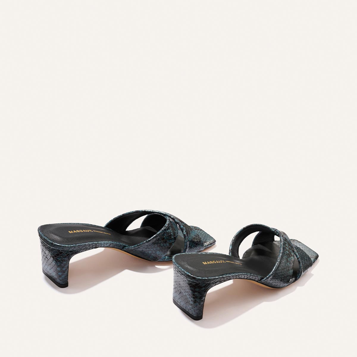 The Selene 50 by Margaux: aqua python-embossed, open-toe heeled sandals with square toes and low block heels, shown on a plain light background.