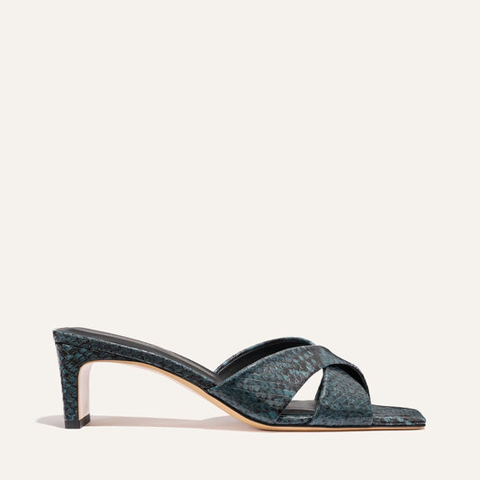 The Selene 50 by Margaux: an aqua python-embossed heeled sandal with crisscross straps, open toe, and slim high heel, showcased on a light background.
