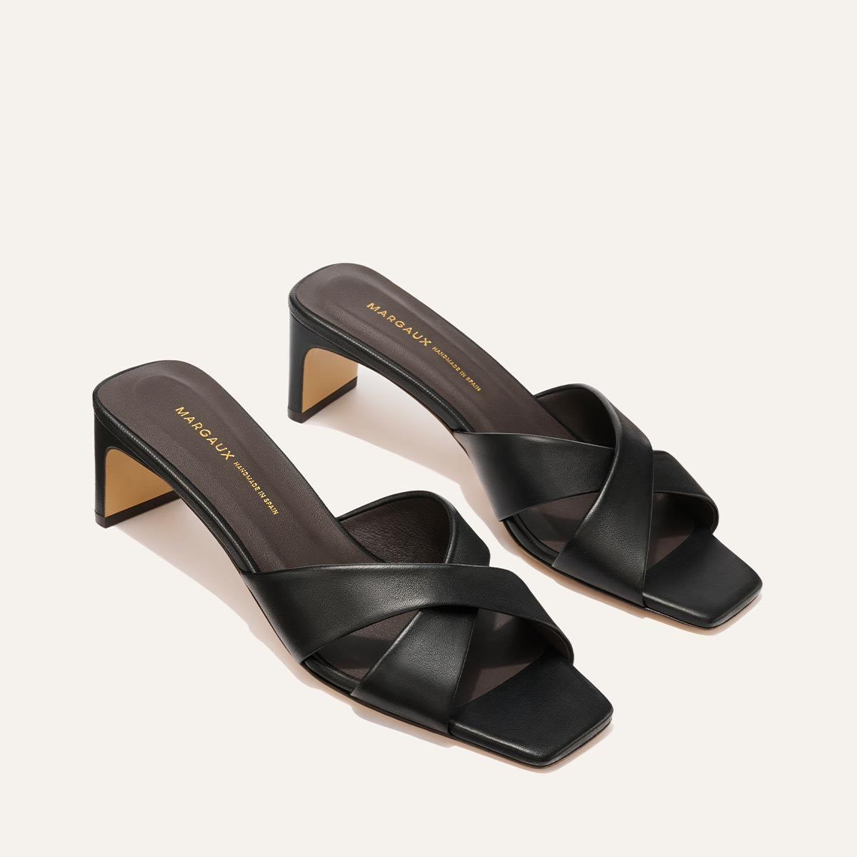 Pair of black high-heeled sandals on a light gray background