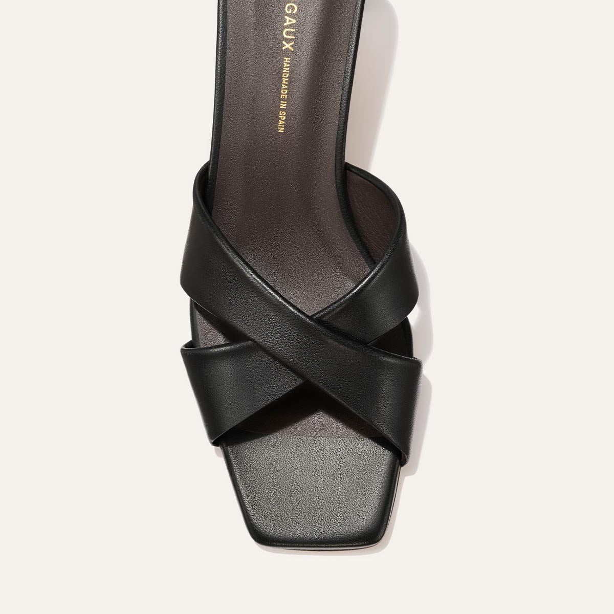 Black sandal with criss-cross straps on a white background