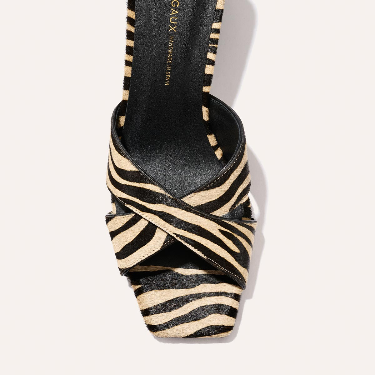 Top view of Margaux’s The Selene 50 sandal in Tan Zebra Haircalf, showcasing crisscross black and beige zebra print straps and a square toe design.