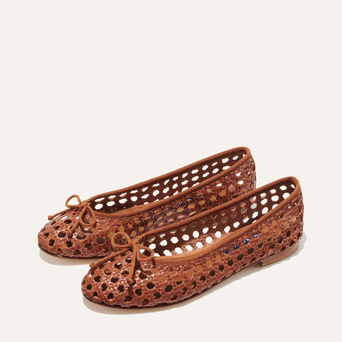The Demi - Saddle Woven Leather by margaux-development: handmade brown woven leather ballet flats with an open lattice design and small front bows, shown on a plain off-white background.